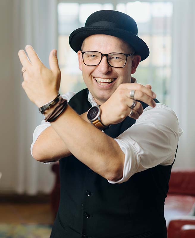 Författaren David Stavegård, med vacker hatt och tjusiga smycken. Foto av Niclas Fasth.